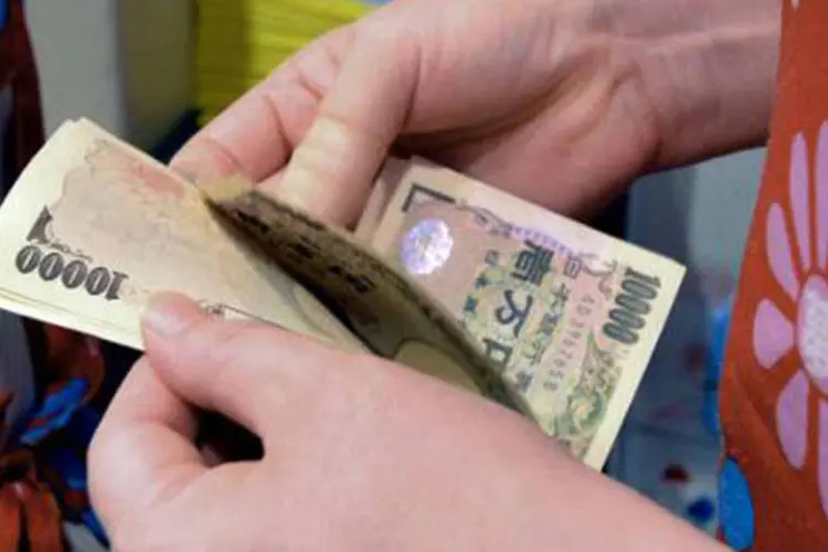Japonesa conta notas de iene: alta dos impostos motivou a aprovação de um pacote no valor de seis trilhões de ienes (US$ 61 bilhões) (Yoshikazu Tsuno/AFP)