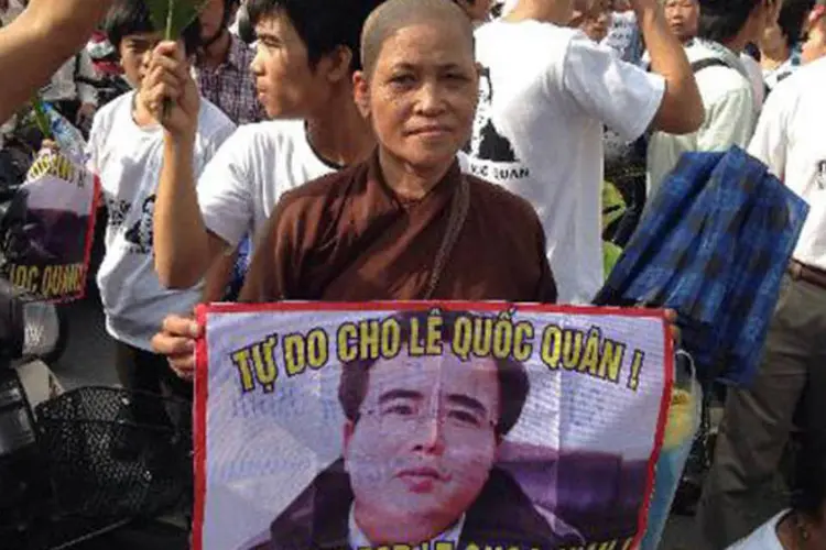 Manifestante com cartaz do advogado e ativista Le Quoc Quan: julgamento foi considerado "político" por ONGs (Cat Barton/AFP)