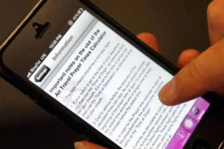 Aplicativo em iPhone: uma vez registrados os detalhes do voo, o aplicativo envia um alerta com o horário das cinco orações diárias e a direção de Meca (AFP)