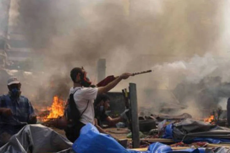 Manifestante enfrenta a polícia no Cairo: um jornalista da AFP contou 124 corpos em um dos necrotérios improvisados (Mosaab el-Shamy/AFP)