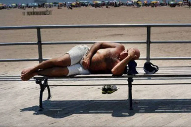 
	Homem em banco da praia durante onda de calor: at&eacute; 2040, a frequ&ecirc;ncia de epis&oacute;dios de calor extremos vai aumentar, diz cientista
 (Spencer Platt/AFP)