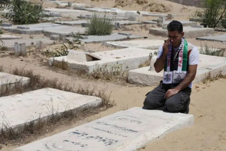 
	Ex-prisioneiro palestino chora em frente a t&uacute;mulo: decis&atilde;o se deve tamb&eacute;m porque manuten&ccedil;&atilde;o de t&uacute;mulos e dados se tornou &quot;dor de cabe&ccedil;a&quot; para Israel
 (Ibraheem Abu Mustafa/Reuters)