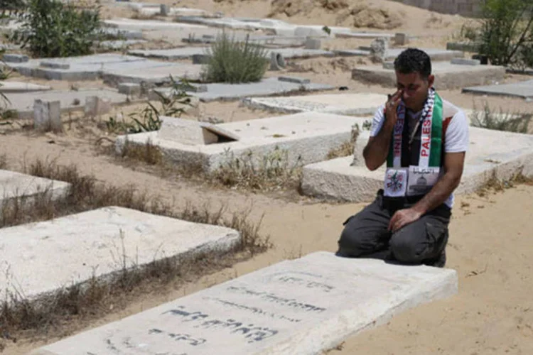 
	Ex-prisioneiro palestino chora em frente a t&uacute;mulo: decis&atilde;o se deve tamb&eacute;m porque manuten&ccedil;&atilde;o de t&uacute;mulos e dados se tornou &quot;dor de cabe&ccedil;a&quot; para Israel
 (Ibraheem Abu Mustafa/Reuters)