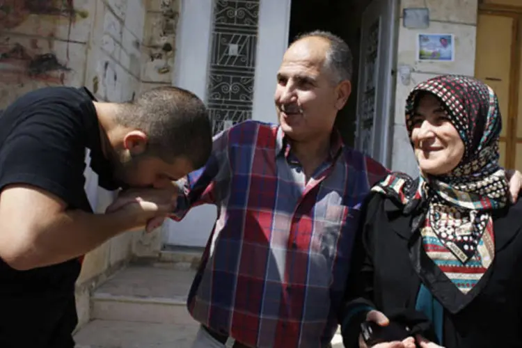 Prisioneiro palestino libertado (c), com esposa e filho: Israel libertará palestinos em troca do reinício das negociações de paz (Ammar Awad/Reuters)