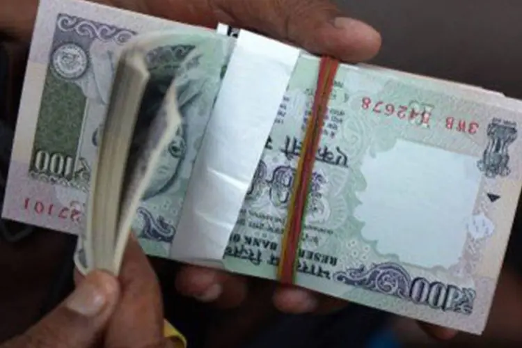 Indiano exibe cédulas de rupia: moeda indiana registra a maior desvalorização entre as grandes moedas asiáticas (Dibyangshu Sarkar/AFP)