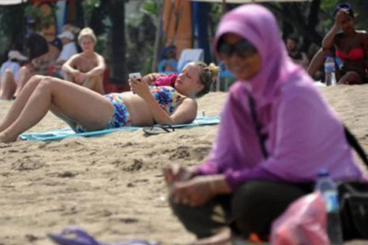 Muçulmana usando véu perto de turistas estrangeiros com biquínis: concurso "não é adequado aos ensinos islâmicos ", disse ministro (Sonny Tumbelaka/AFP)