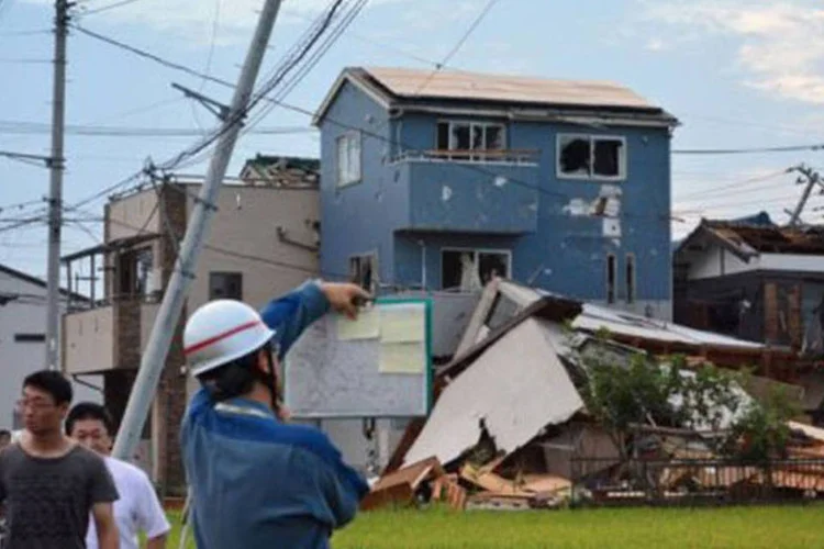 Casas destruídas na passagem de tornado no Japão: imagens exibidas pela televisão mostram o tornado carregando e lançando objetos (Kazuhiro Nogi/AFP)