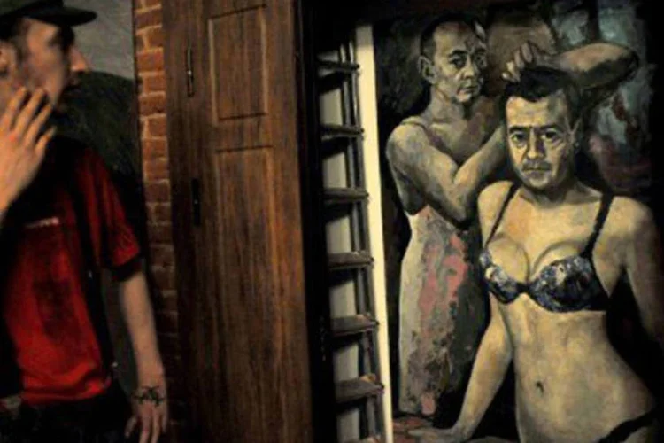 Visitante olha quadro com Vladimir Putin e Dmitri Medvedev usando lingerie: proprietária do museu foi libertada horas depois (Olga Maltseva/AFP)