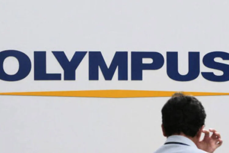 Homem em frente ao logo da Olympus, em Tóquio: foi descoberto que o grupo nipônico e sua filial britânica falsificaram contas por 20 anos (Getty Images)