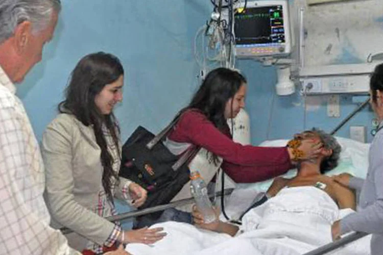 Parentes visitam Gomez Cincunegui no hospital: após problemas com moto, ele decidiu ir a pé para a Cordilheira, onde se perdeu (AFP)