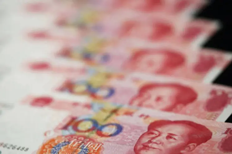 
	Notas de iuane, a moeda chinesa: Pequim quer a inclus&atilde;o do iuan na cesta de moedas como parte de sua meta estrat&eacute;gica de longo prazo de reduzir a depend&ecirc;ncia do d&oacute;lar
 (Tomohiro Ohsumi/Bloomberg)