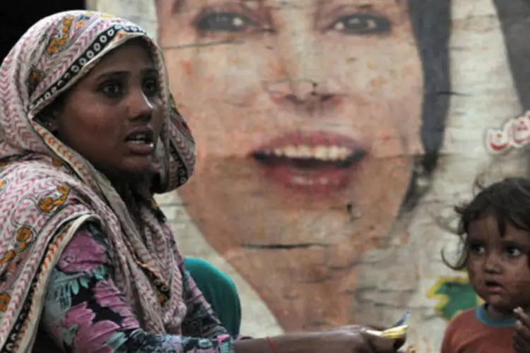Mãe e filha paquistanesas, com imagem ao fundo da ex-premiê Benazir Bhutto: cerca de 9.000 mulheres foram estupradas em 2011 no Paquistão, segundo organização (Getty Images)