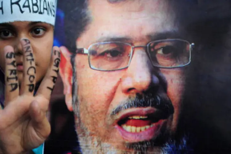 
	Ativista em apoio a Mohamed Mursi:&nbsp;Mursi &eacute; processado junto com outros 14 dirigentes da Irmandade Mu&ccedil;ulmana por incidentes em 2012
 (Getty Images)
