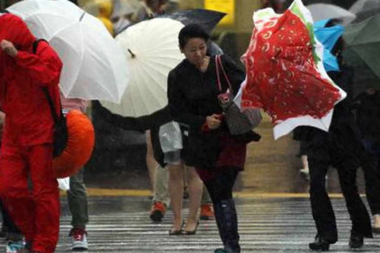 Japoneses lutam contra fortes ventos provocados pelo tufão Man-yi: tempestade está provocando chuvas torrenciais e ventos de até 160 quilômetros por hora (Yoshikazu Tsuno/AFP)