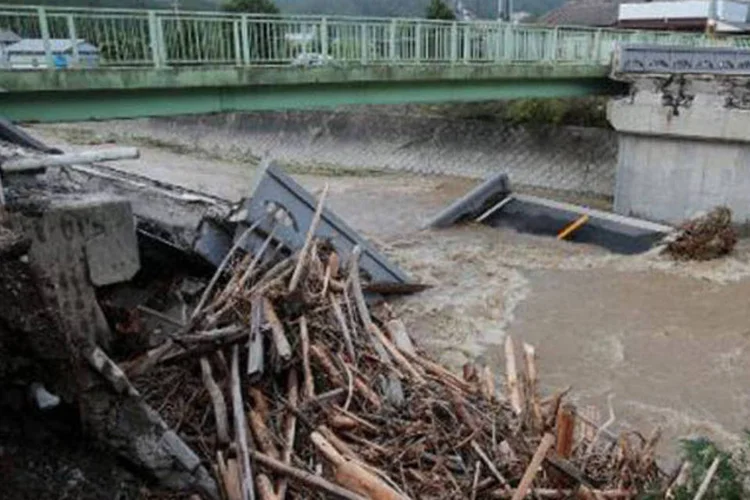 Ponte destruída depois da cheia de um rio no Japão: chuvas ameaçam a região de Fukushima, o que aumenta os temores a respeito da acidentada central nuclear (Jiji Press/AFP)