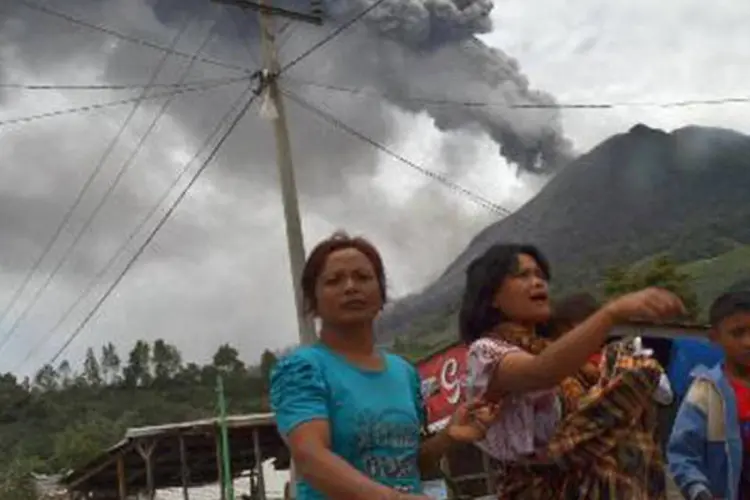 Moradores fogem de nuvem de fumaça vinda da erupção do vulcão Sinabung: ocorreu uma nova erupção que foi ouvida num raio de 10 km (Sutanta Aditya/AFP)