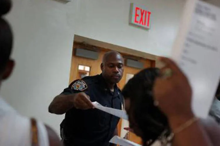 Mulheres conversam com recrutadores da Polícia de NY: pedidos de seguro aumentaram 15.000 em relação à semana anterior para chegar aos 309.000 pedidos (Spencer Platt/AFP)