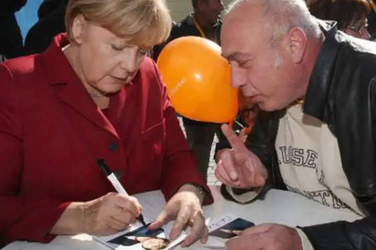 Simpatizante conversa com Angela Merkel: aos 59 anos, a chanceler alemã é muito popular no país e uma das líderes mais respeitadas no mundo (Bernd Wustneck/AFP)