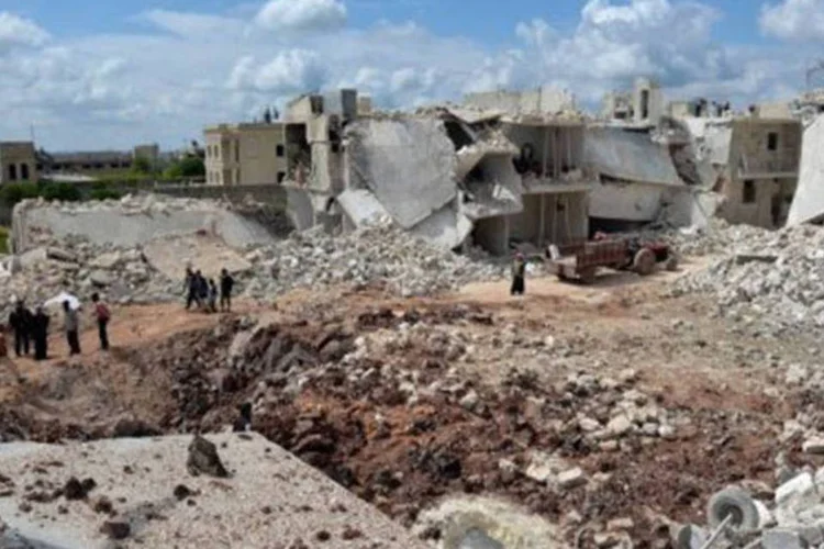 Pessoas caminham perto de casas destruídas: as duas partesestabeleceram um cessar-fogo (Miguel Medina/AFP)