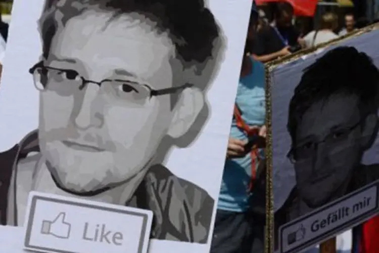 
	Manifestantes com placas de Edward Snowden: novas den&uacute;ncias afirmam que os EUA espionaram comunica&ccedil;&otilde;es de aliados, como Angela Merkel
 (John Macdougall/AFP)