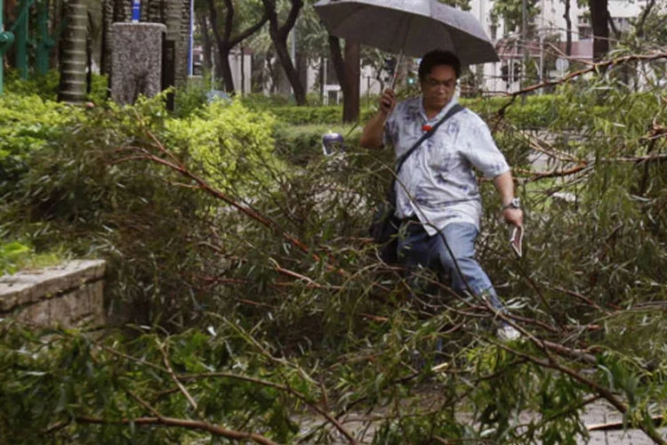 Homem caminha em área destruída pelas chuvas na Ásia: fortes chuvas caem na região após a passagem do tufão Usagi (Bobby Yip/Reuters)
