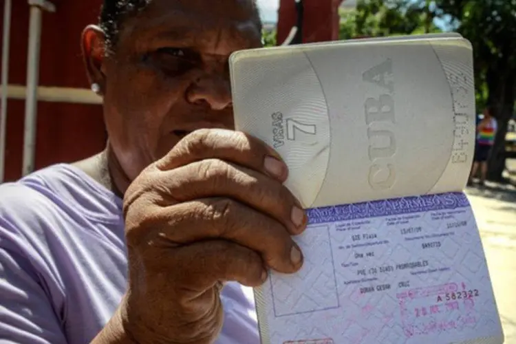 
	Cubana mostra seu passaporte com a permiss&atilde;o de viajar em Havana: pelos dados oficiais, h&aacute; cubanos em mais de 150 pa&iacute;ses, a maioria nos EUA
 (Adalberto Roque/AFP)