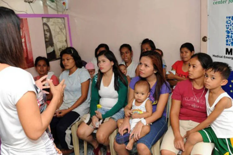 
	Profissional da sa&uacute;de conversa sobre fomas de controle de natalidade em Manila, nas Filipinas: o ensino de educa&ccedil;&atilde;o sexual nos col&eacute;gios tamb&eacute;m &eacute; uma exig&ecirc;ncia da lei
 (Jay Directo/AFP)