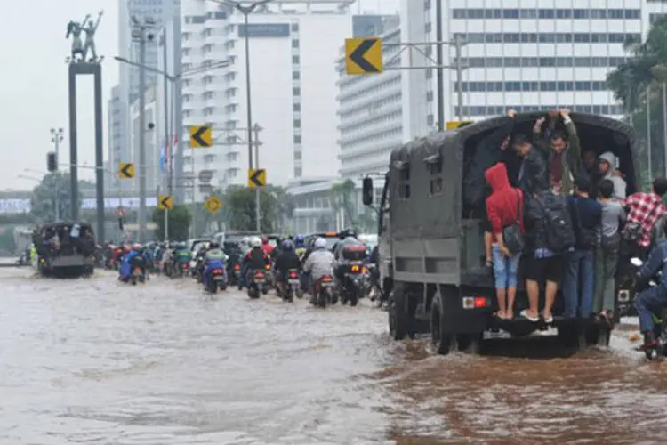 
	Pessoas andam em carros militares em 18 de janeiro na capital da Indon&eacute;sia, Jacarta: boa parte do distrito de neg&oacute;cios da cidade permanece submerso
 (Adek Berry/AFP)