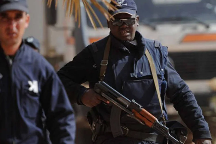 Polícia vigia enquanto vítimas do conflito na Argélia são levadas em caminhões: os sequestradores lançaram o ataque em protesto pela operação contra os islamitas do Mali (Farouk Batiche/AFP)