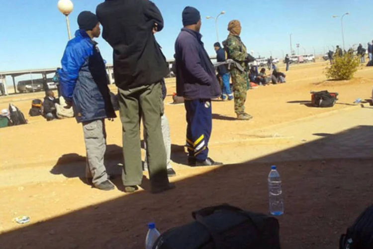 
	Ref&eacute;ns de islamitas argelinos no campo de In Amenas; o homem em uniforme camuflado &eacute; um dos extremistas: 5 estrangeiros permanecem desaparecidos
 (AFP)