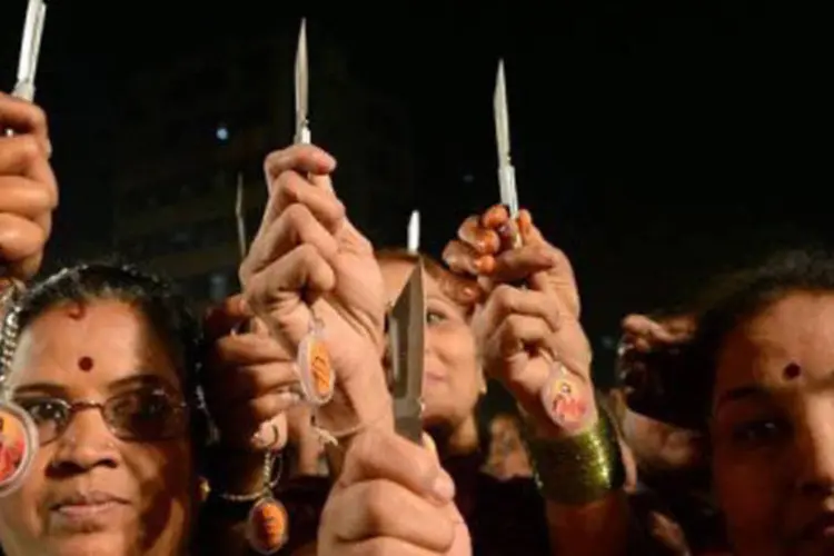 
	Mulheres indianas mostram suas facas enquanto posam para fotos em Mumbai: o Shiv Sena tem a inten&ccedil;&atilde;o de distribuir 21 mil armas brancas no estado de Maharastra
 (Punit Paranjpe)