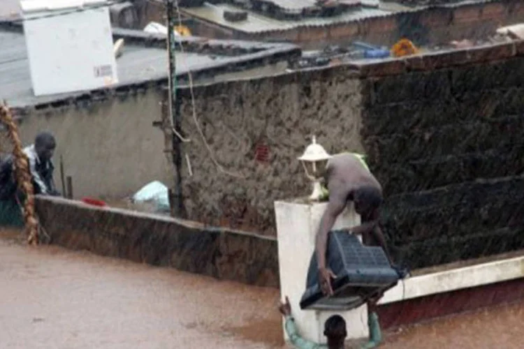 
	Morador de Maputo entrega um aparelho de televis&atilde;o durante uma enchente: a situa&ccedil;&atilde;o n&atilde;o p&ocirc;de ser avaliada em alguns povoados isolados
 (Stringer/AFP)