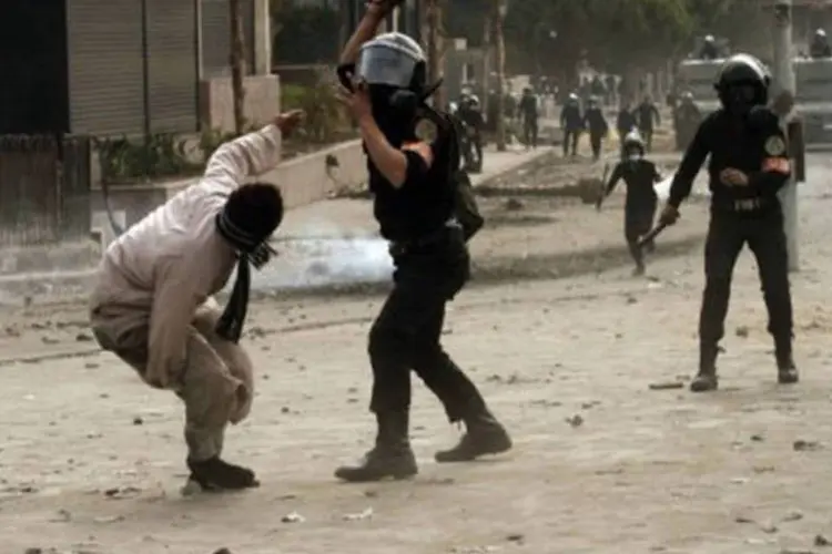 
	Policial eg&iacute;pcio agride um manifestante durante um protesto na pra&ccedil;a Tahrir: a viol&ecirc;ncia registrada nos &uacute;ltimos dias causou um total de 47 mortes
 (Mohammed Abed/AFP)