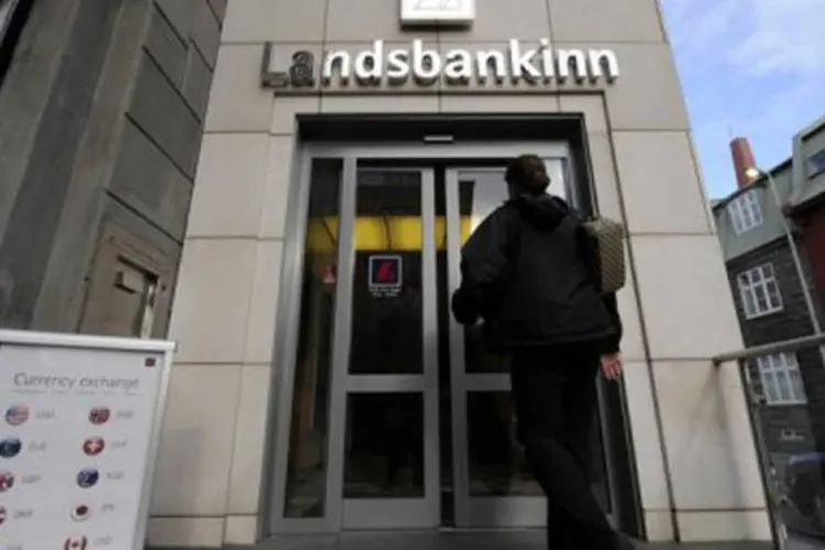 
	Mulher entra em uma ag&ecirc;ncia do banco Landsbanki: a decis&atilde;o era amplamente esperada para saber se o dinheiro p&uacute;blico deve ser usado para salvar bancos falido
 (Olivier Morin/AFP)