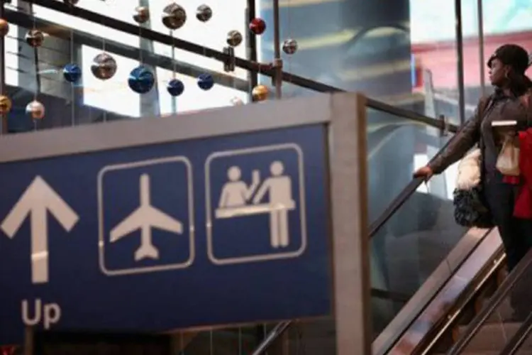 
	Uma passageira no aeroporto de Chicago: para 2013, a tend&ecirc;ncia de alta ser&aacute; mantida a um ritmo levemente inferior
 (Scott Olson/AFP)