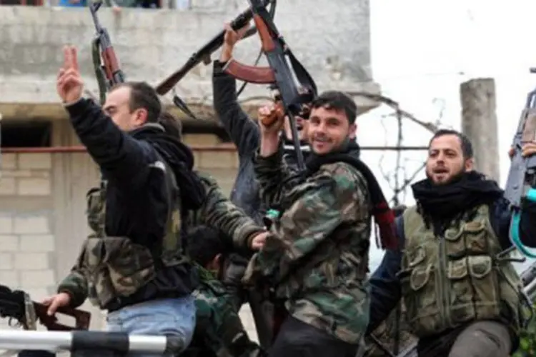 Rebeldes celebram a tomada do vilarejo de Aljanodiya, Síria, 30 de janeiro, 2013
 (Aamir Qureshi/AFP)