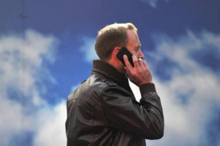 
	Homem fala ao celular: as redes m&oacute;veis popularizaram a telefonia no Brasil
 (Carl Court/AFP)