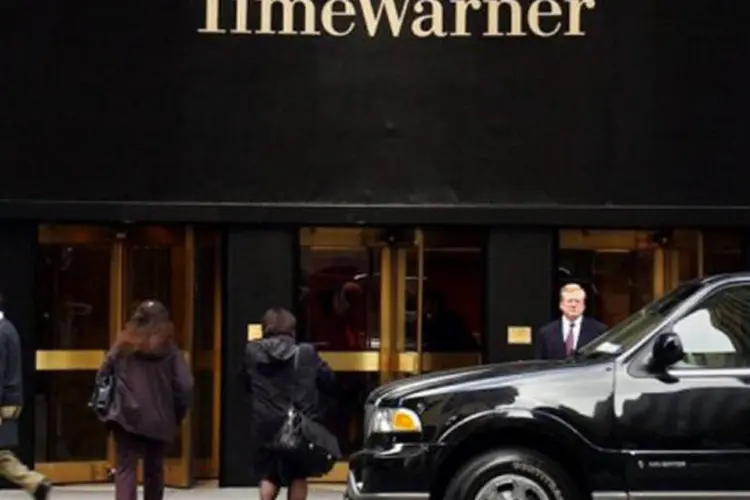 
	Pedestres em frente ao pr&eacute;dio da TimeWarner em Nova York: o lucro por a&ccedil;&atilde;o, sem contar elementos excepcionais, foi de 3,28 d&oacute;lares
 (Stan Honda/AFP)