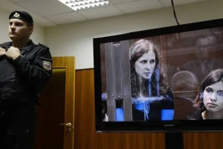 
	Policial perto de televis&atilde;o mostrando duas integrantes do &quot;Pussy Riot&quot;: elas citam a liberdade pessoal e de express&atilde;o e o direito a um julgamento justo
 (Natalia Kolesnikova/AFP)