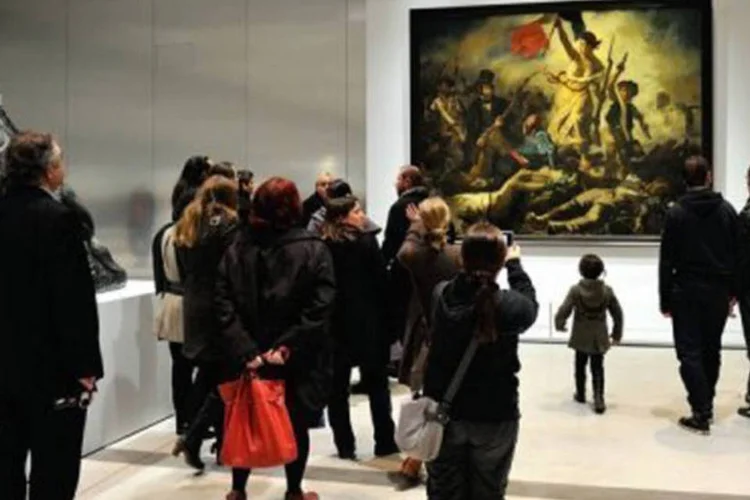Pessoas admiram o quadro "A liberdade guiando o Povo" de Delacroix: "a inscrição, superficial, poderá ser limpa facilmente", indicou o museu (Philippe Huguen/AFP)