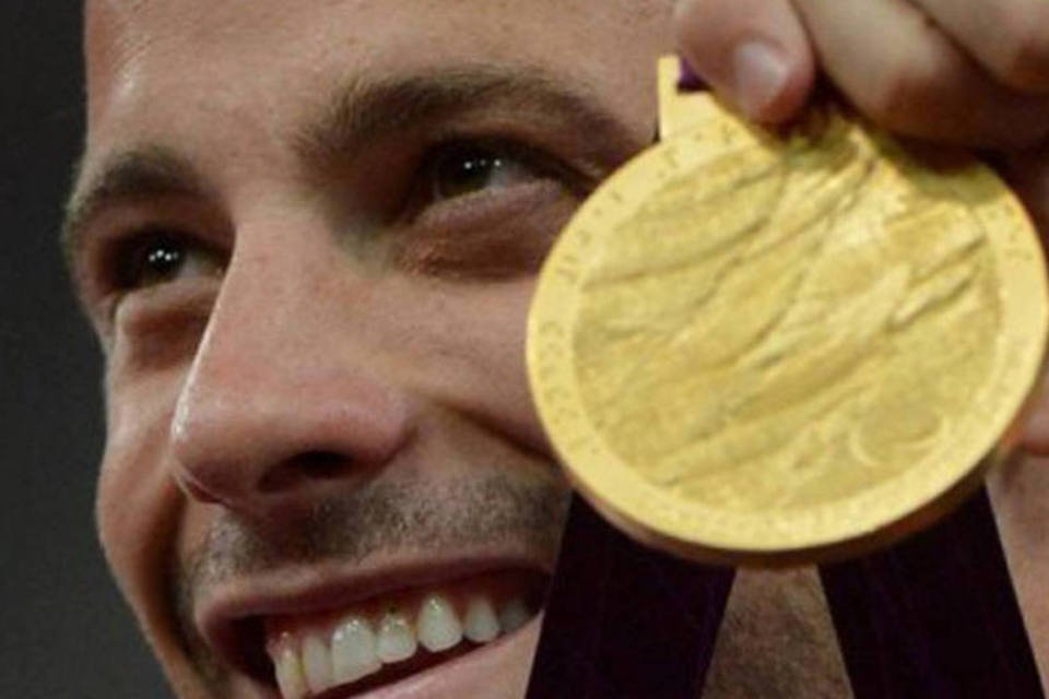 
	Oscar Pistorius mostra medalha de ouro conquistada nos Jogos Paral&iacute;mpicos de Londres: Pistorius foi acusado de matar a namorada em sua casa de Pret&oacute;ria
 (Ben Stansall/AFP)