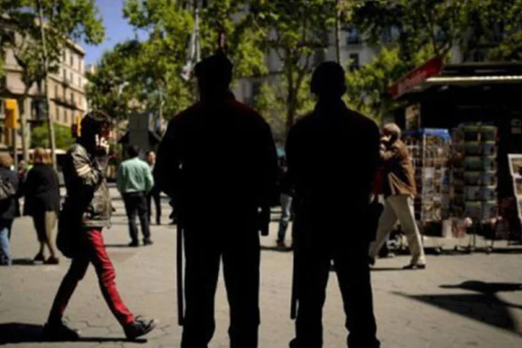 
	Policiais patrulham uma rua de Barcelona: o grupo teria cometido homic&iacute;dios e tr&aacute;fico de drogas na cidade
 (Pedro Armestre/AFP)