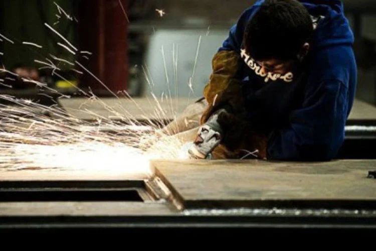 
	Soldador trabalha nos EUA: a economia dos Estados Unidos recuou a quase zero no quarto trimestre de um crescimento de 0,8% no terceiro trimestre
 (Jim Watson/AFP)