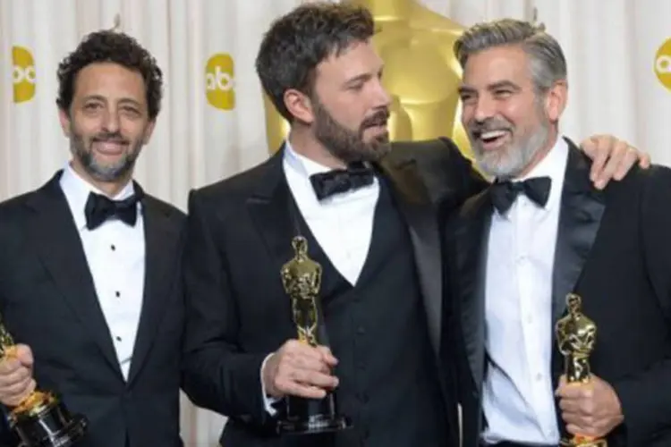Ben Affleck (C), George Clooney (R) e Grant Heslov celebram a conquista do Oscar (Joe Klamar/AFP)