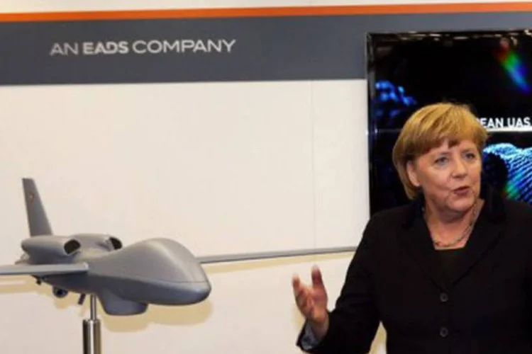 
	Angela Merkel posa em frente a poster da Cassidian: a empresa destacou, no entanto, que vai permanecer no mercado brasileiro, que considera um mercado com futuro
 (Jens Buttner/AFP)