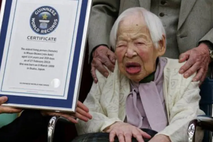Misao Okawa, reconhecida como a mulher mais velha do mundo, ao lado do certificado oferecido pelo Livro Guinness dos Recordes
 (Jiji Press/AFP)
