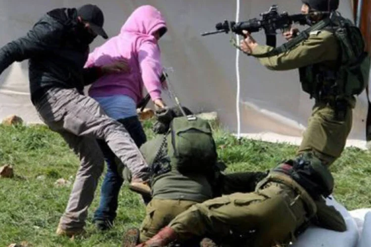 Manifestantes palestinos resistem ao serem detidos por soldados israelenses perto de Burin, na Cisjordânia
 (Jaafar Ashtiyeh/AFP)