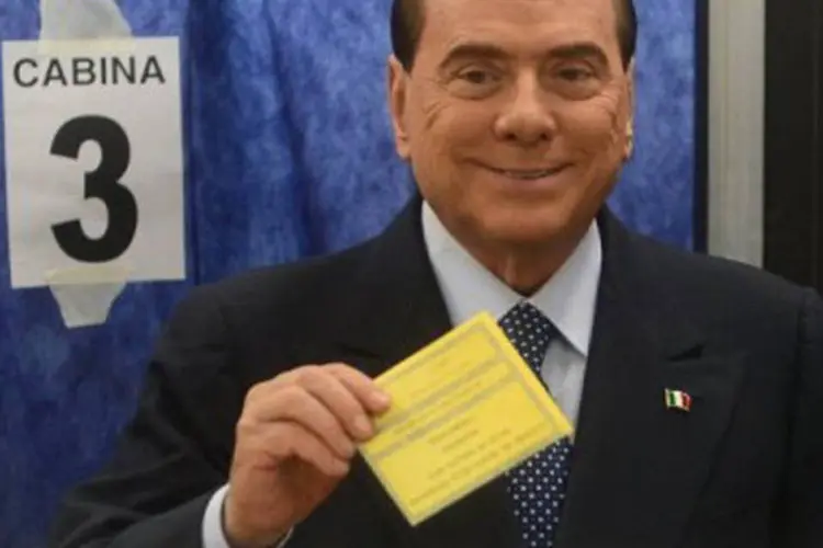 
	Silvio Berlusconi vota durante elei&ccedil;&otilde;es italianas em Mil&atilde;o: ele teria pago tr&ecirc;s milh&otilde;es de euros ao senador De Gregorio
 (Olivier Morin/AFP)