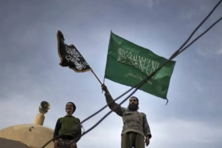 Membros da brigada rebelde Hamzah com bandeiras islamitas em cima de mesquita em Deir Ezzor
 (Zac Baillie/AFP)