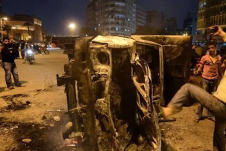 
	Manifestantes atacam carro da pol&iacute;cia ap&oacute;s dist&uacute;rbios na cidade do Cairo: nos arredores destes edif&iacute;cios ocorrem confrontos entre manifestantes e policiais
 (Khaled Desouki/AFP)